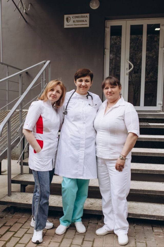 Лікарі клініки біля входу та вивіска «Сімейна клініка Святого Пантелеймона»